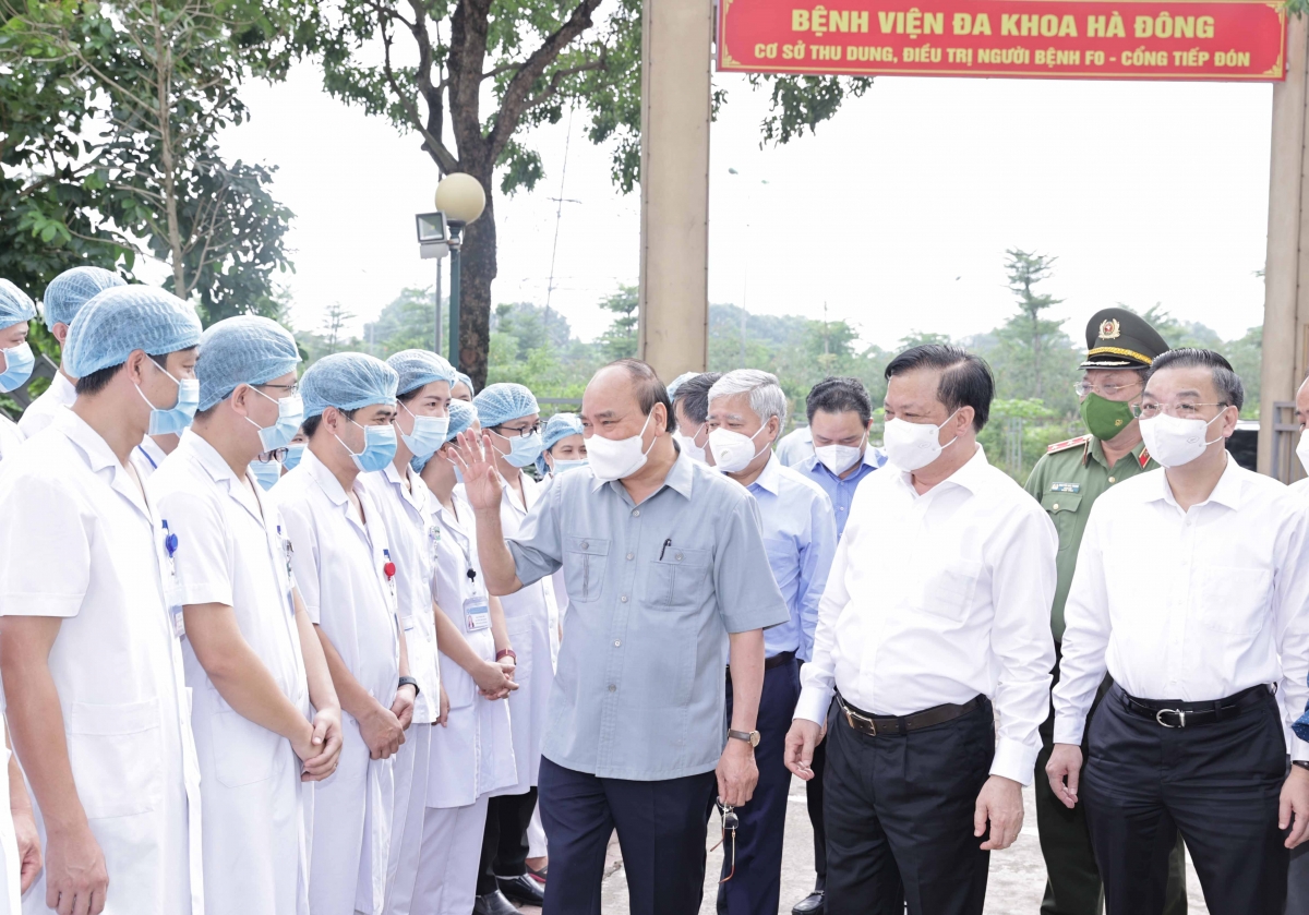 Chủ tịch nước Nguyễn Xuân Phúc tặng quà các nhân viên y tế làm việc tại cơ sở thu dung, điều trị bệnh nhân COVD-19 của Bệnh viện Đa khoa Hà Đông tại phường Hoàng Liệt, quận Hoàng Mai